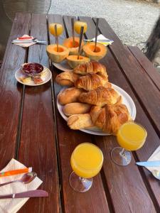 佩鲁日Chambres d hotes THE RESID的一张桌子,上面放着羊角面包和橙汁