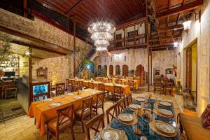 哈塔伊Le Reve Butik Otel的餐厅设有木桌、椅子和吊灯。