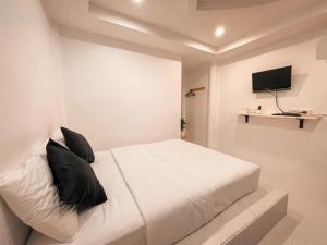 格兰岛KohLan Hansa的卧室配有带黑色枕头的白色床