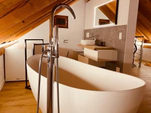 LionzaCasa Mille Sassi的一间带大浴缸和水槽的浴室