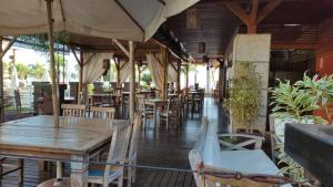巴西利亚Life Resort - 2 quartos, 2 banheiros的餐厅设有木桌、椅子和遮阳伞