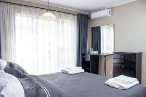 UmtaliInviting 3-Bed Apartment In The City的一间卧室配有一张床、一个梳妆台和一扇窗户。