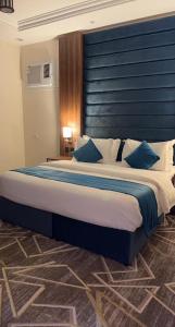 艾卜哈فيو إن للشقق الفندقية - المحالة的一间卧室配有一张大床和蓝色床头板