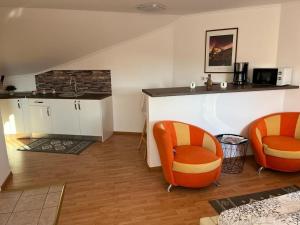 锡吉什瓦拉Panorama Studio Sighisoara的厨房配有2把橙色椅子和台面