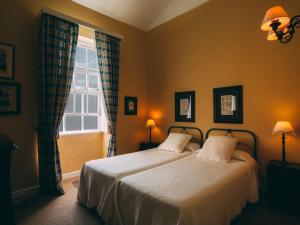 洛西洛斯卡萨阿马里利亚田园酒店的一间卧室设有两张床和窗户。