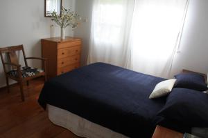 彭特派因阿斯提克度假屋的一间卧室配有一张床、一个梳妆台和一扇窗户。