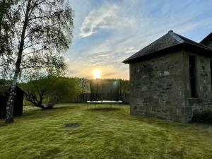 金克雷格*Cool, cosy cottage in the heart of the Highlands*的庭院里带桌子的石头建筑