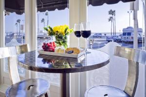 纽波特海滩纽波特海滩酒店 的一张桌子,上面放着一盘食物和两杯葡萄酒