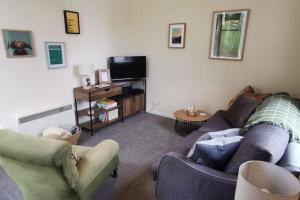 金克雷格*Cool, cosy cottage in the heart of the Highlands*的带沙发和电视的客厅