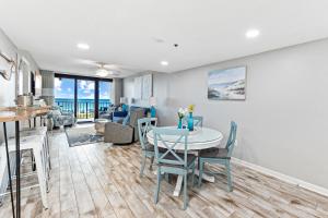 奥兰治比奇Updated Beachfront 2 BR 2 Bath Condo with direct views of the beach的厨房以及带桌椅的起居室。