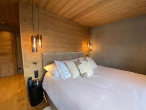 克莱恩 蒙塔纳Chalet 7 Luxury Chalet with Cinema room的卧室配有白色的木墙床