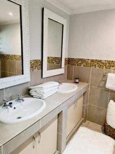 杰米斯顿Finna's lovely 1-bedroom open plan vacation home.的浴室设有2个水槽和2面镜子