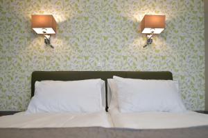 罗加斯卡斯拉提纳TI Hotel的卧室配有一张带两盏灯的墙壁床。