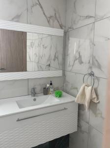 莫纳斯提尔Splendide appartement au PALM LAKE RESORT的白色的浴室设有水槽和镜子