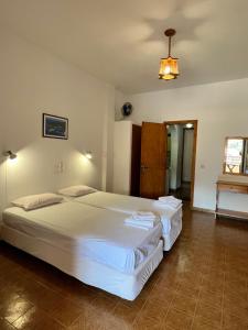 拉卡Vasiliki apartments的一间卧室配有两张床和吊灯。