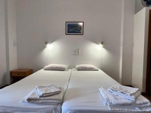 拉卡Vasiliki apartments的一间卧室配有两张带毛巾的床