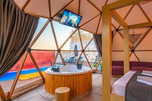 卡斯Kalkan Dome Suites & Deluxe-Glamping Holiday in Kalkan的一间设有浴缸的客房,并在帐篷内提供一台电视。