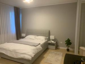 塔古玖EM04- Studio premium的卧室配有白色的床和植物