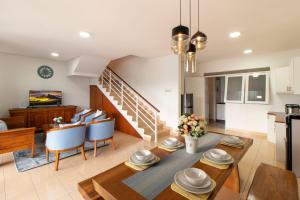 万隆VILLA KELUARGA Syariah Resor Dago Pakar Bandung - View Bukit的厨房以及带桌椅的起居室。