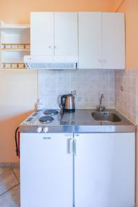 派莱卡斯Villa Myrto的厨房配有白色橱柜和水槽