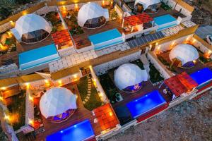 卡斯Kalkan Dome Suites & Deluxe-Glamping Holiday in Kalkan的享有带游泳池和大楼的度假村的空中景致