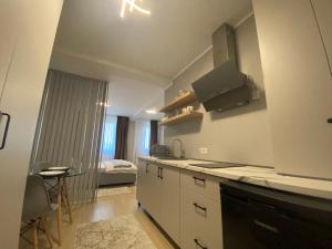 塔古玖EM04- Studio premium的一间厨房,配有白色的橱柜和一张位于客房内的床