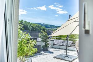 贝斯特维希Ferienwohnung Landparadies im Sauerland的阳台享有带雨伞的房屋美景