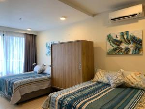 关丹PUTEH Timurbay Beachfront Private Suite Kuantan的一间卧室设有两张床和大窗户