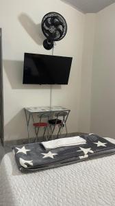 麦德林Aparta estudio amoblado 3 Medellin, San joaquin的一间卧室配有一张带电视和桌子的床。