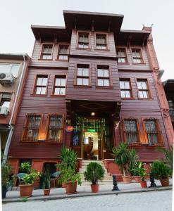 伊斯坦布尔Le Safran Suite Hotel的一座大型木结构建筑,前面有植物