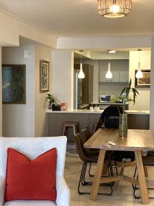 开普敦Canal Quays 507的用餐室以及带桌子和红色枕头的厨房