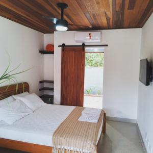 巴拉-沙希Hakuna Studios Barra do Sahy的一间卧室设有一张床和一个窗口