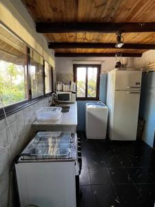 拉弗洛雷斯塔LO DE MARILITA的一间带冰箱和水槽的小厨房