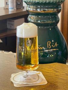ReuthGasthaus Hubertus的坐在桌子上喝杯啤酒