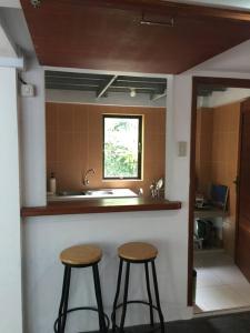 班达亚齐Banda Aceh Batoh Homestay - private - fits up to 10 persons的厨房配有2把吧台凳和水槽