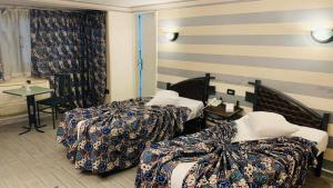 开罗开罗哈瓦那大酒店的酒店客房设有两张床和一张桌子。