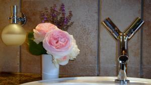 Neu LübbenauJANISCHs Fewo im Spreewald的浴室水槽上一束粉红色玫瑰花