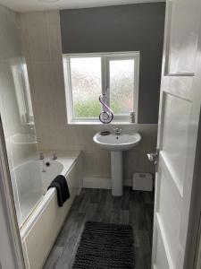 谢菲尔德Sheffield spa view 2 bed house free parking的一间带水槽和浴缸的浴室以及窗户。