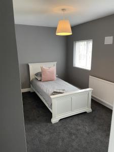谢菲尔德Sheffield spa view 2 bed house free parking的卧室配有白色床和粉红色枕头