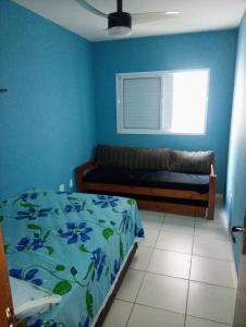 大普拉亚Apartamento Vidal con Wi-Fi Praia Grande Avi的蓝色的卧室设有床和窗户