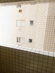 大普拉亚Apartamento Vidal con Wi-Fi Praia Grande Avi的浴室设有白色瓷砖墙壁和窗户。