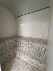 莱昂ARVA Spa París的墙上铺有白色瓷砖的空浴室