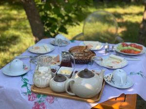 培拉特Xho's Forest Guest House的餐桌上放着食物和茶壶