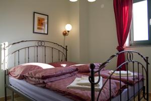 多布林吉Villa Mikulica的一间卧室配有一张带粉色床单的床和一扇窗户。