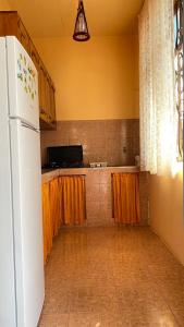 高尼奥Holiday Home in Gonio的厨房配有白色冰箱和橙色窗帘