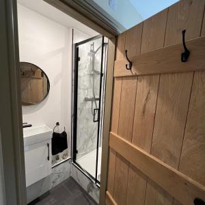 彭里斯Honeysuckle Cottage & Whinfell Studio的浴室设有玻璃门和镜子
