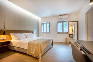 阿里奥波利斯Armantanis Luxury Suites的卧室配有一张床、一张书桌和窗户。