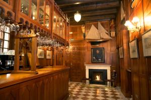 塞维利亚塞维利亚雅典娜酒店的一间带壁炉的酒吧,位于一间木墙房间内