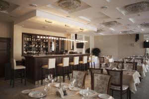 明斯克明斯克维多利亚扎姆科沃伊酒店的一间带桌椅的餐厅和一间酒吧