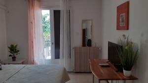 佩皮尼昂Bel appartement avec grande terrasse ensoleillée et jardin的一间卧室配有一张床、一张桌子和一台电视